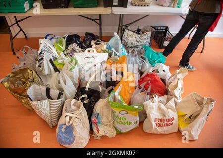 Ein nicht identifizierbarer Freiwilliger bei einer Lebensmittelbank, der Kisten mit gespendetem Essen sortiert, um sie für die Verteilung an Mitglieder der örtlichen Gemeinde in Not vorzubereiten. M Stockfoto