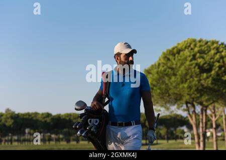 schöne orientalische Golfer Tragetasche und zu Fuß zum nächsten Loch am Golfplatz Stockfoto
