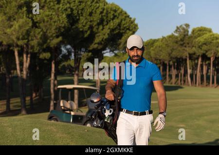 schöne orientalische Golfer Tragetasche und zu Fuß zum nächsten Loch am Golfplatz Stockfoto