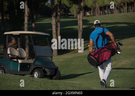 schöne orientalische Golfer Tragetasche und zu Fuß zum nächsten Loch am Golfplatz Stockfoto
