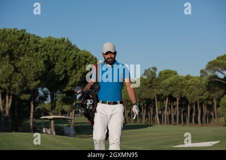 schöne orientalische Golfer Tragetasche und zu Fuß zum nächsten Loch am Golfplatz Stockfoto
