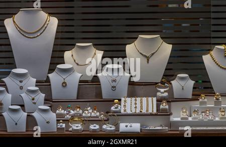 Schmuck Schaufenster mit verschiedenen Schmuckstücken aus Gold und Silber Ohrringe Halsketten und Armbänder zum Verkauf in einem Schaufenster. Stockfoto