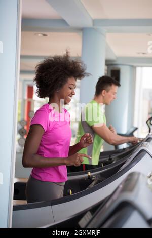 junge Leute Exercisinng Cardio am Laufband laufen Chine im modernen Fitnessraum Stockfoto