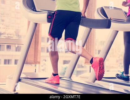 junge Leute Exercisinng Cardio am Laufband laufen Chine im modernen Fitnessraum Stockfoto