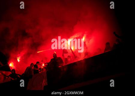 Fußball-Hooligans mit Maske halten Fackeln in Feuer, während Ihre Lieblingsmannschaft Unterstützung bei einem Spiel im Stadion Stockfoto