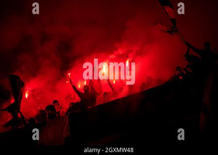 Fußball-Hooligans mit Maske halten Fackeln in Feuer, während Ihre Lieblingsmannschaft Unterstützung bei einem Spiel im Stadion Stockfoto