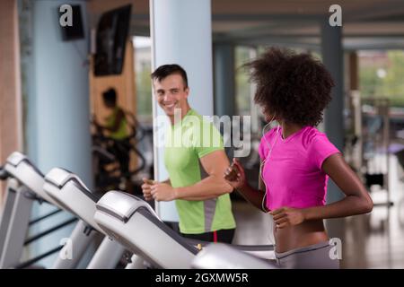 junge Leute Exercisinng Cardio am Laufband läuft Maschine im modernen Fitnessraum Stockfoto