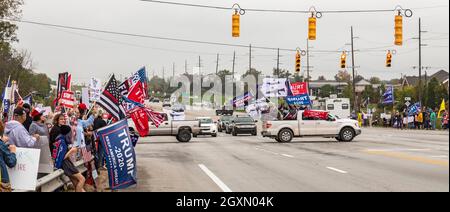 Howell, Michigan, USA. Oktober 2021. Die Republikaner protestieren, als Präsident Joe Biden Michigan besucht, um seinen Build Back Better Plan zu fördern. Ein Lastwagen voller junger Männer winkte Trump-Banner und Flaggen mit Sturmwaffen. Kredit: Jim West/Alamy Live Nachrichten Stockfoto