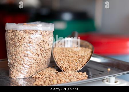 Wiegen von Linsen auf einer digitalen Waage. Trockene Körner. Stockfoto