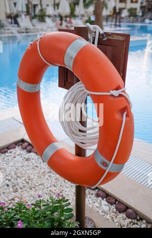 Rote Rettungsring und Seile, um Leben zu retten, wenn Menschen in der Nähe des Pools ertrunken werden. Stockfoto