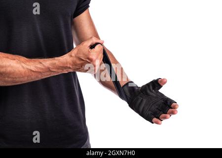 Fitness-Mann im Training setzen Fitness-Handschuhe in weißen Hintergrund, Fitness-Konzept, Sport-Konzept. Nahaufnahme Stockfoto