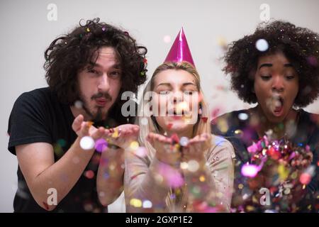 Konfetti Party Multiethnics glückliche junge Menschen Gruppe feiern Silvester beim Tanzen und viel Spaß zu Hause Stockfoto