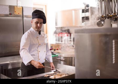 Chefkoch Kochen, Braten vom Grill. Verkauf und Essen Konzept Stockfoto