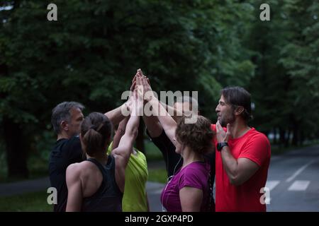 Gruppe von gesunden Läufer, fünf auf einander beim Erfolg feiern nach dem Training. Stockfoto