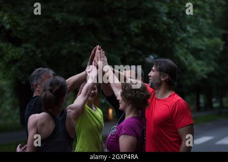 Gruppe von gesunden Läufer, fünf auf einander beim Erfolg feiern nach dem Training. Stockfoto