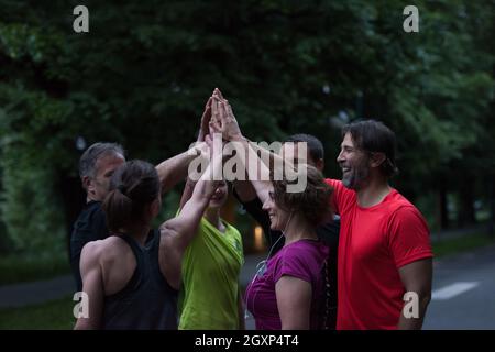 Gruppe von gesunden Läufer, fünf auf einander beim Erfolg feiern nach dem Training. Stockfoto