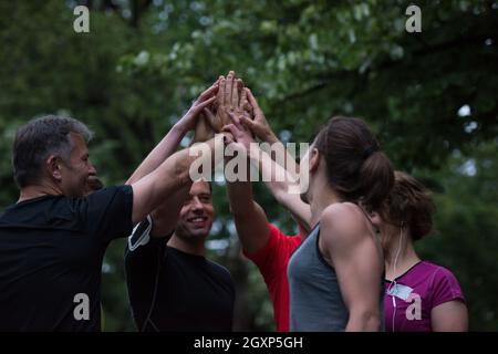 Gruppe von gesunden Läufer, fünf auf einander beim Erfolg feiern nach dem Training. Stockfoto