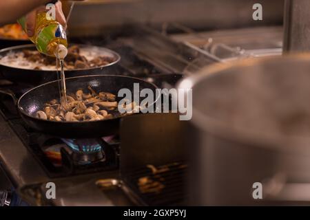 Chefkoch Kochen, Braten im Wok Pfanne. Verkauf und Essen Konzept Stockfoto