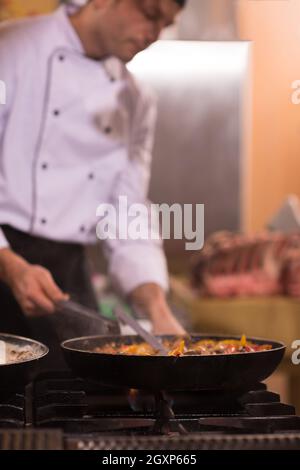 Chefkoch Kochen, Braten im Wok Pfanne. Verkauf und Essen Konzept Stockfoto