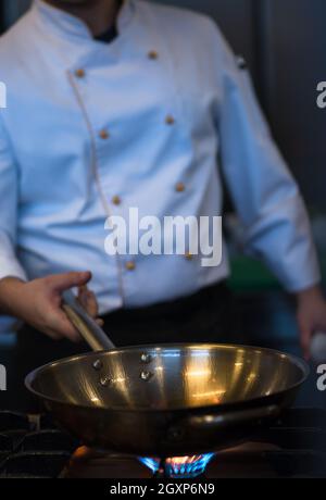 Chefkoch Kochen, Braten im Wok Pfanne. Verkauf und Essen Konzept Stockfoto