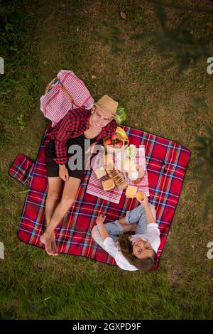 Paar in der Liebe genießen Picknick zeit Trinken und Essen in der wunderschönen Natur am Flussufer, Ansicht von oben Stockfoto