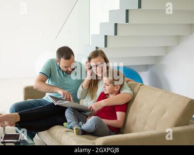 glückliche junge Familie mit kleinen Jungen erfreut sich im modernen Wohnzimmer ihre Heimat Luxusvilla Stockfoto