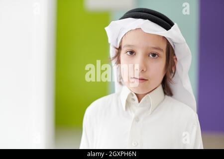 Porträt des kleinen arabischen Jungen in traditioneller Kleidung während des Ramadan Festmonat zu Hause. Das islamische Halal Essen und Trinken im modernen westlichen I Stockfoto