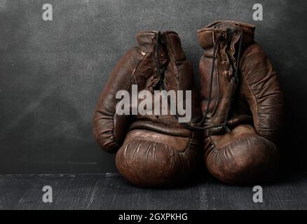Braune Leder Vintage Boxhandschuhe auf schwarzem Hintergrund, Sportausrüstung Stockfoto