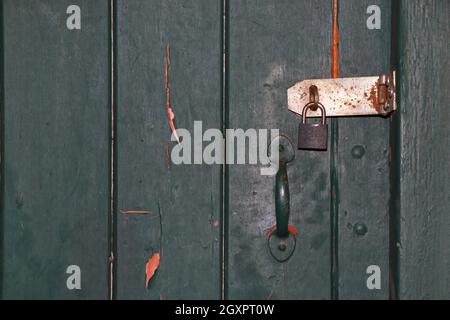 Lackierte alte Tür mit Schloss und Vorhängeschloss in Nahaufnahme Stockfoto