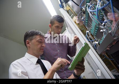 Business-Menschen-Gruppe arbeitet an Tablet-Computer, Netzwerk-Ingenieure im Serverraum Stockfoto