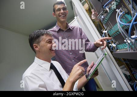 Business-Menschen-Gruppe arbeitet an Tablet-Computer, Netzwerk-Ingenieure im Serverraum Stockfoto