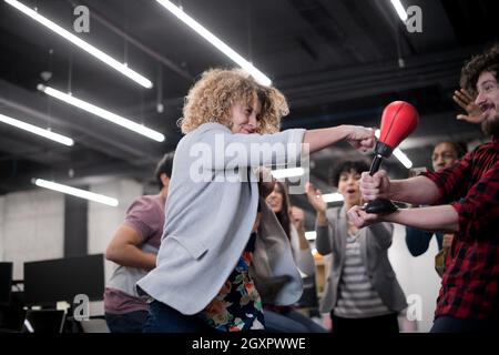 Multiethnics startup Business Team von Software-Entwicklern Spaß beim Boxen im Büro, aufgeregt, diverse Mitarbeiter Lachen genießen Sie lustige Aktivität Stockfoto