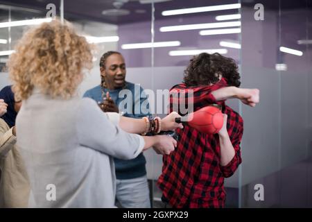 Multiethnics startup Business Team von Software-Entwicklern Spaß beim Boxen im Büro, aufgeregt, diverse Mitarbeiter Lachen genießen Sie lustige Aktivität Stockfoto