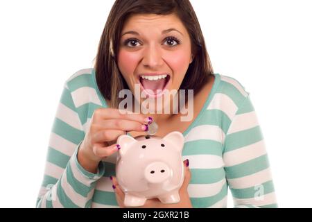 Ziemlich lächelnd ethnischen weiblich, eine Münze in ihr rosa Sparschwein, Isolated on White Background. Stockfoto