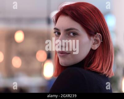 Redhead Business Frau porträtiert als Influencer im kreativen modernen Coworking Startup Open Space Office Stockfoto