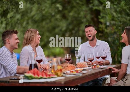 Gruppe von glücklichen Freunden mit Picknick französisch Abendessen Party im Freien Im Sommer Urlaub in der Nähe des Flusses in schöner Natur Stockfoto