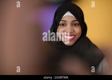 Eine afrikanisch-muslimische Frau mit einem schönen Lächeln in Hijab-Posen im Studio Stockfoto