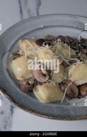 Käseravioli in einer toskanischen cremigen Sauce mit sautierten Crimini-Pilzen Stockfoto