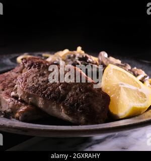 Gebratene Schweinekoteletts mit Honig-Senf-Pilzsoße und Pasta Stockfoto