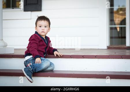 Süße Melancholie Mischlinge Junge sitzt auf der Veranda Schritte. Stockfoto