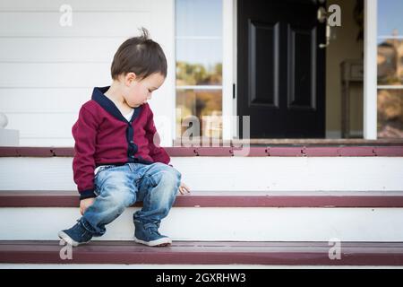 Süße Melancholie Mischlinge Junge sitzt auf der Veranda Schritte. Stockfoto