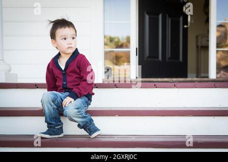 Süße Melancholie Mischlinge Junge sitzt auf der Veranda Schritte. Stockfoto