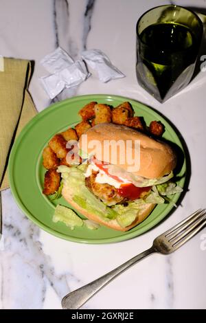 Putenburger auf Ciabatta-Rolle mit Provolonkäse und Tater Tots Stockfoto