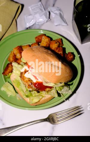 Putenburger auf Ciabatta-Rolle mit Provolonkäse und Tater Tots Stockfoto