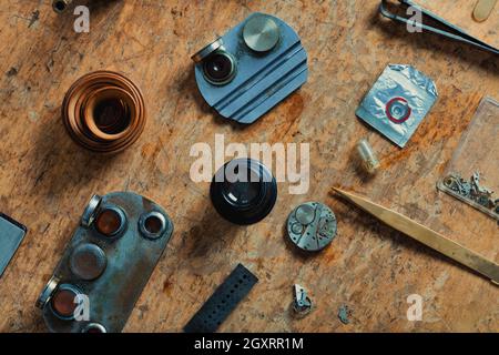 Vintage Uhrmacher Werkzeuge und alte Uhrwerk auf einer hölzernen Werkbank in einer Draufsicht Stockfoto