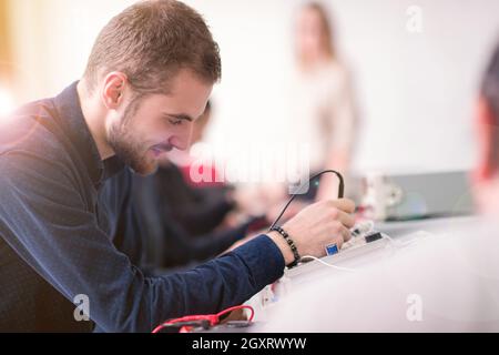 Gruppe von jungen Studenten, die berufliche Praxis mit Lehrer in das elektronische Klassenzimmer, Bildung und Technologie Konzept Stockfoto