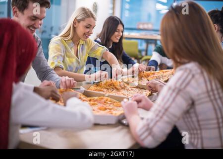 Freundlich diverse multiethnischen Business Team Essen teilen Pizza zusammen im Startup office, multirassischen Mitarbeiter Mitarbeiter Gruppe genießen Pause sprechen. l Stockfoto