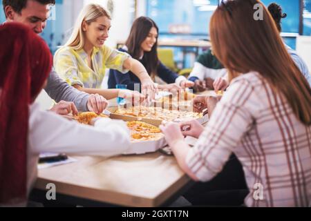Freundlich diverse multiethnischen Business Team Essen teilen Pizza zusammen im Startup office, multirassischen Mitarbeiter Mitarbeiter Gruppe genießen Pause sprechen. l Stockfoto