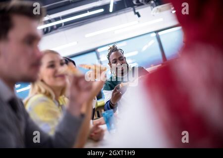 Freundlich diverse multiethnischen Business Team Essen teilen Pizza zusammen im Startup office, multirassischen Mitarbeiter Mitarbeiter Gruppe genießen Pause sprechen. l Stockfoto
