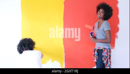 glückliche junge multiethnischen paar Malerei Innenwand des neuen Hauses Stockfoto